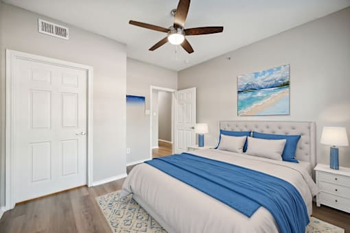 A bedroom with a large bed and a ceiling fan.