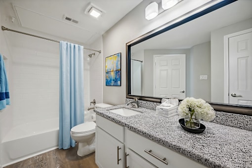 A bathroom with a toilet, sink, and shower.