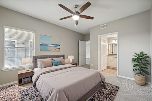 A bedroom with a large bed and a ceiling fan.