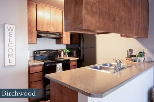 a kitchen with wooden cabinets and a stainless steel sink