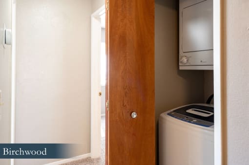 a laundry room with a washer and dryer in it and a wooden door