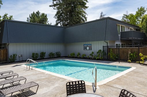 View of gated community pool with lounge chairs and seating