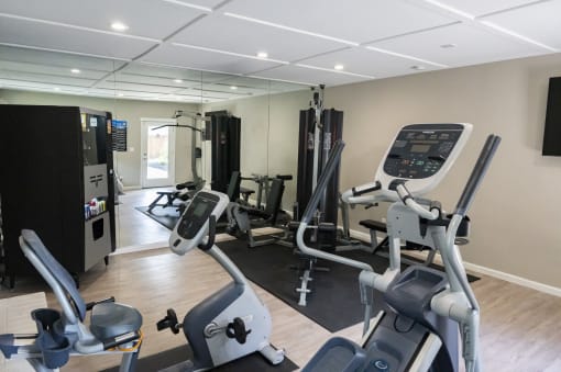 View of community fitness center with stationary bike and weight machines