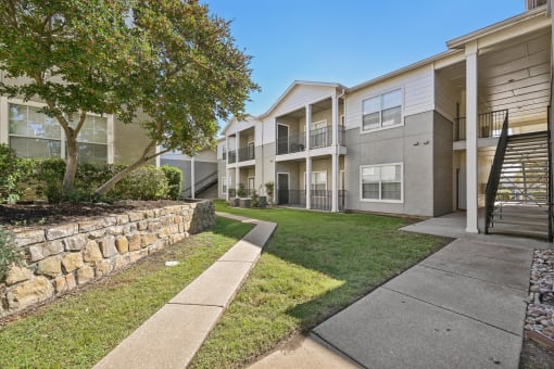 our apartments have a spacious courtyard with grass and a stone wall