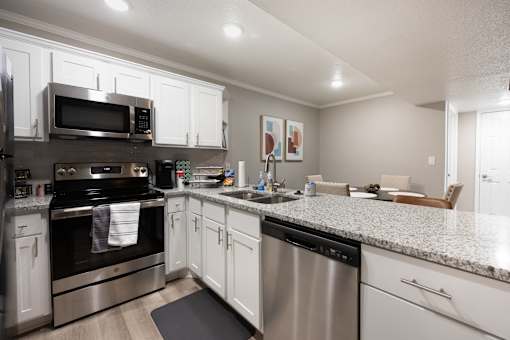 A modern kitchen with stainless steel appliances and white cabinets.