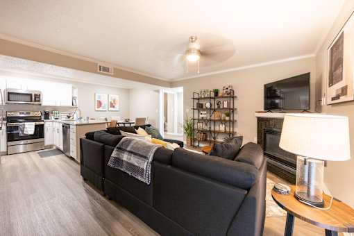A black couch with a blanket on it sits in a living room.