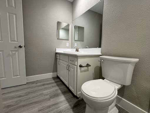 A white toilet sits next to a sink in a bathroom.