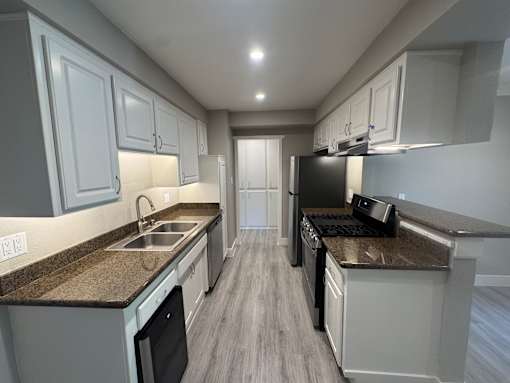 A kitchen with a sink, stove, and oven.