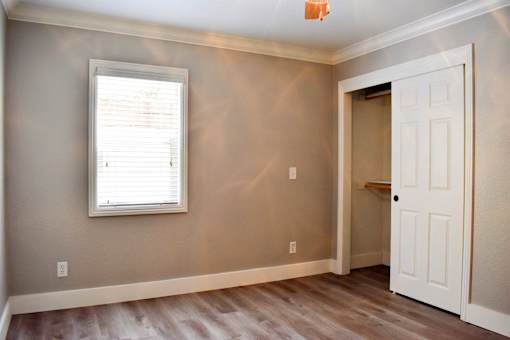 A room with a white door and a window with blinds.
