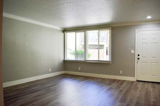 A room with a white door and a window with blinds.