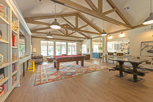 a large living room with a pool table in the center at Midtown Sam Houston Apartments, Huntsville, Texas