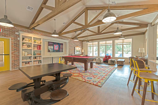 a game room with a pool table and a television at Midtown Sam Houston Apartments, Huntsville, Texas