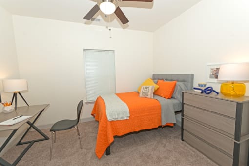 a bedroom with a bed and a ceiling fan at Midtown Sam Houston Apartments, Huntsville, TX