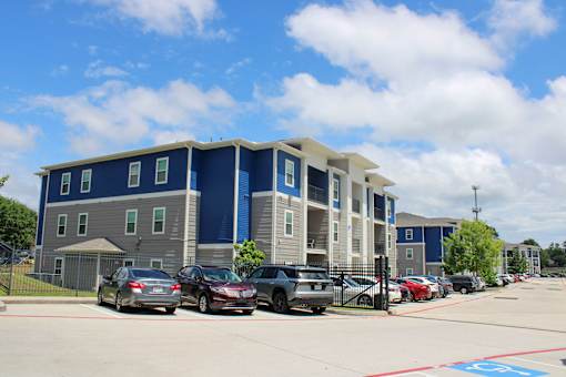 A parking lot with cars and a building in the background.
