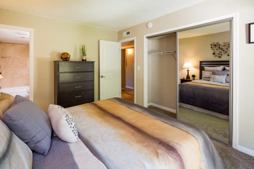 furnished bedroom with large mirrored door closet