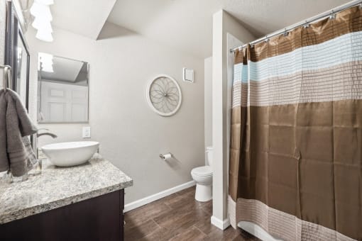 a bathroom with a shower and a toilet and a sink