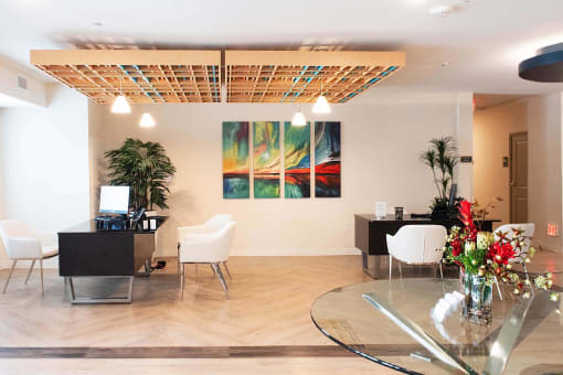 a living room with a table and chairs and a painting on the wall  at Parks Residential - Richardson, Richardson