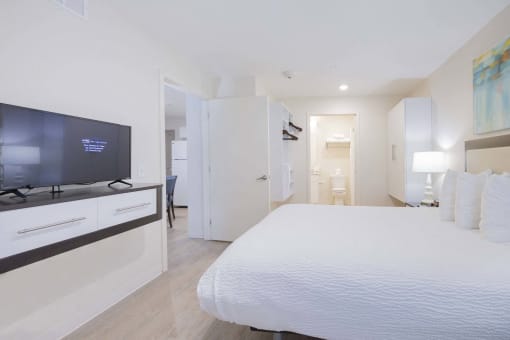 a bedroom with a large bed and a tv at Parks Residential - Richardson, Richardson, Texas