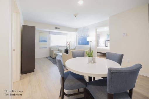 a living room and dining room with a white table and chairs at Parks Residential - Richardson, Texas, 75082