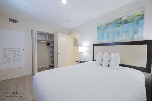 a bedroom with a large bed and a door to a bathroom at Parks Residential - Richardson, Richardson, Texas