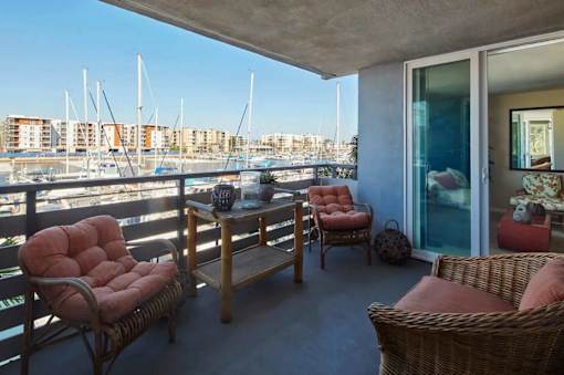 A balcony with a table and chairs overlooking a marina.