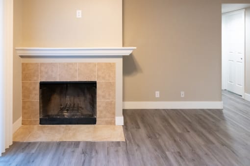 the living room with a fireplace and a wooden floor