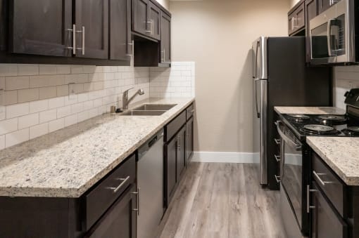 renovated kitchen with granite countertops and stainless steel appliances at the preserve at greatstone