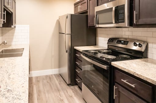 an updated kitchen with stainless steel appliances and wood flooring