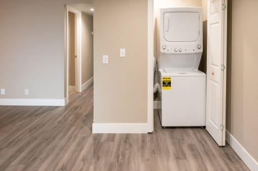 a laundry room with a washer and dryer and a door to a hallway
