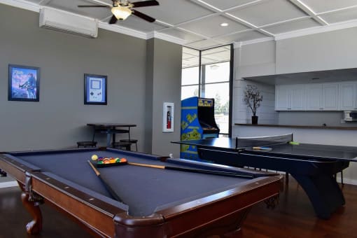 View of community lounge with billiards table, arcade machine