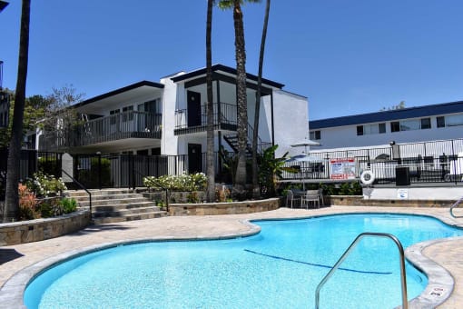 Angled view of pool area, landscaping, and exterior building closest to pool.