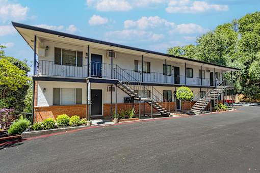 A two-story apartment building with a balcony on the second floor.