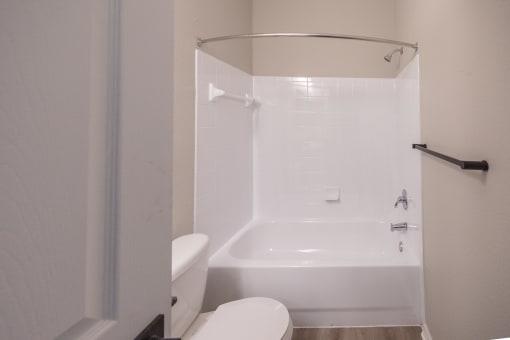 a white bathroom with a toilet and a tub