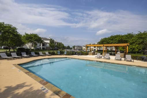 View of pool with grilling area and lounges