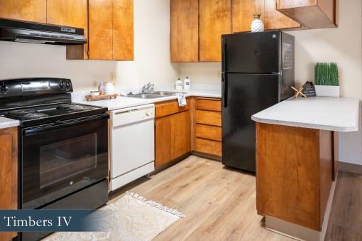 a kitchen with black appliances and white counters and wooden cabinets