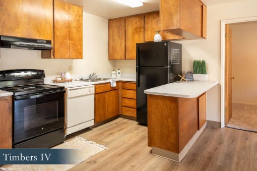 a kitchen with black appliances and wooden cabinets and a white counter top