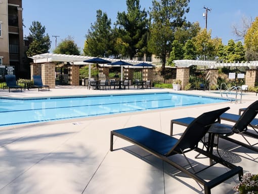 a swimming pool with lounge chairs and umbrellas at Vista Pointe