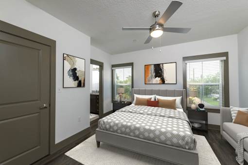 A bedroom with a bed, a couch, and a ceiling fan.