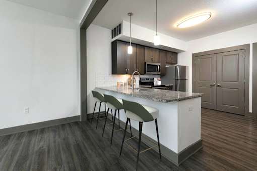 A kitchen with a white counter and brown cabinets.