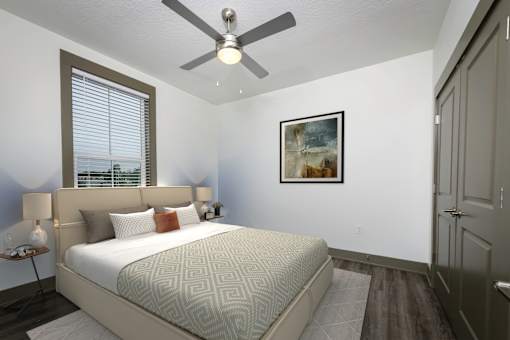 A bedroom with a large bed and a ceiling fan.