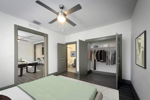 A bedroom with a bed, a ceiling fan, and a wardrobe.