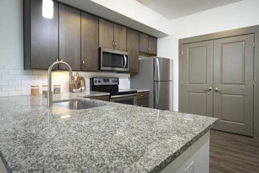 A kitchen with granite countertops and stainless steel appliances.
