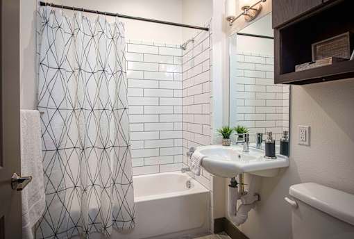A bathroom with a white shower curtain and a white sink.
