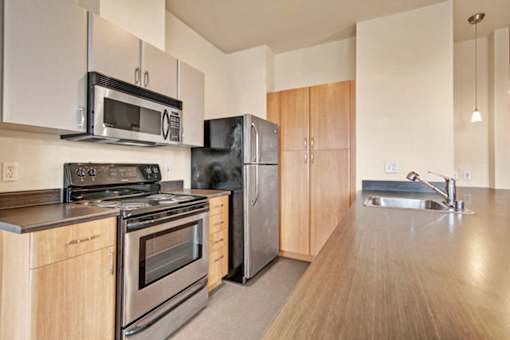 A kitchen with a stove, oven, refrigerator, and microwave.