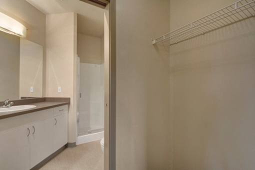 A bathroom with a sink, mirror, and a walk-in shower.
