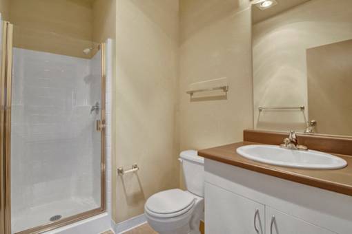 A bathroom with a toilet, sink, and shower.