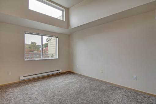 A room with a window and a view of a building outside.