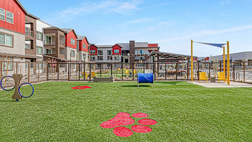 A playground with a blue tarp and red flower pattern on the grass.