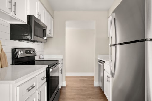 a kitchen with white cabinets and black appliances at Denim Scottsdale, Scottsdale, AZ, 85251