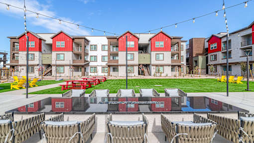 A row of red and white buildings with a lawn in front.